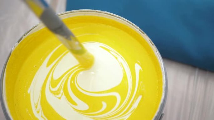 黄色浓缩色涂料与白色涂料混合。壁画概念。慢动作和特写视图