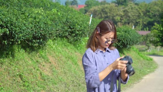 4k年轻亚洲女子使用数码相机拍摄大自然的照片