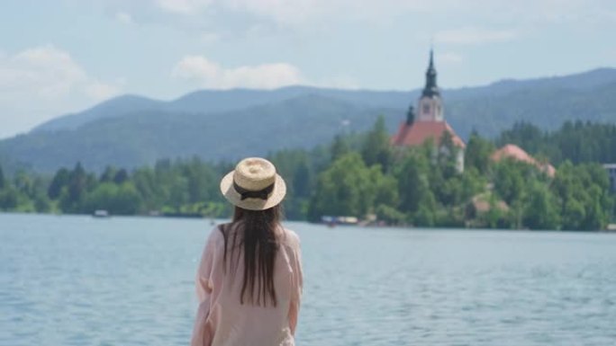 受启发的女人在斯洛文尼亚的布莱德湖上撒手