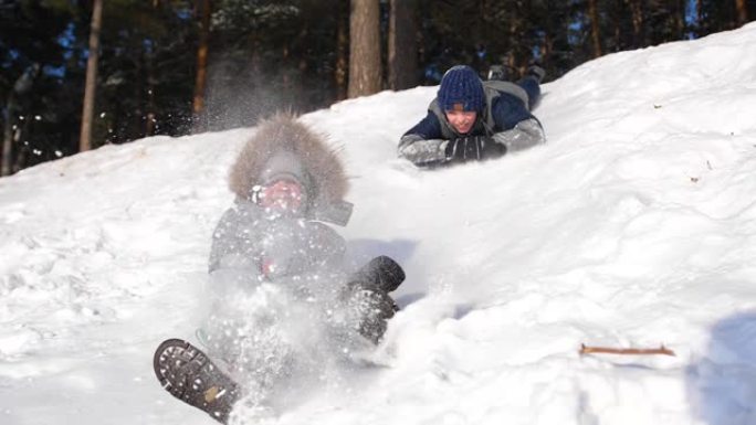 孩子们骑在雪山上。慢动作。白雪皑皑的冬季景观。户外运动