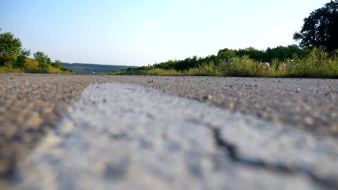 男子在空旷的高速公路上快速驾驶他的摩托车。摩托车手沿着乡村柏油路高速行驶。喜欢速度的家伙。低角度视图