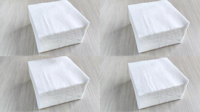木桌上的一堆白色方形餐巾纸