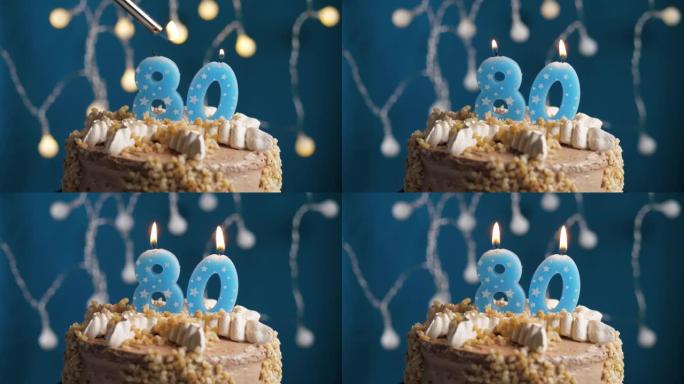 蓝色背景上有80号蜡烛的生日蛋糕。蜡烛着火了。慢动作和特写视图