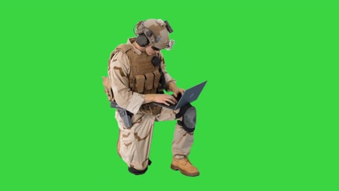 士兵在绿色屏幕上使用笔记本电脑和无线电进行通信
