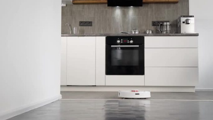 机器人真空吸尘器是现代新工作室公寓的清洁地板，厨房景观