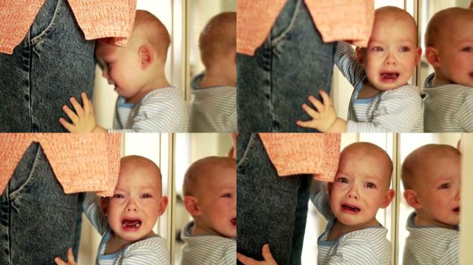 孩子哭了，同时看着镜子里的自己。婴儿在哭，站在镜子前靠近母亲。母亲和孩子，母亲节