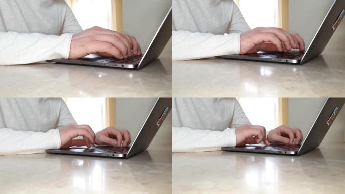 男性双手在笔记本电脑上打字的特写，办公室工作的概念，家庭，远程工作，在线交流