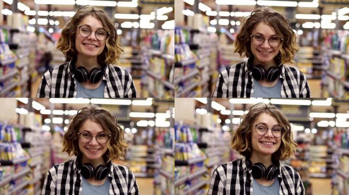 肖像年轻女子站在镜头前，微笑着在超市感受快乐女孩购物脸零售店。漂亮卷曲的女性顾客，戴着耳机，脖子上戴