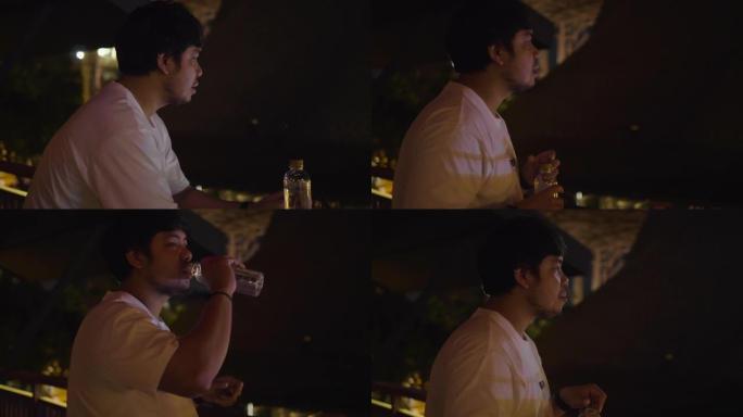 亚洲男子在餐馆喝水