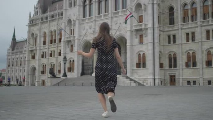 匈牙利布达佩斯，兴奋的女孩奔向议会