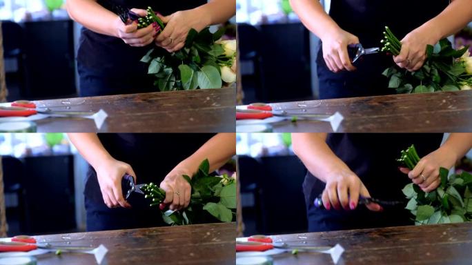 花店的女人准备花在商店里切玫瑰茎，特写手。