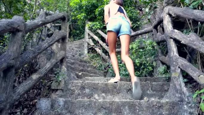穿着短裤的女人在山上走上石阶
