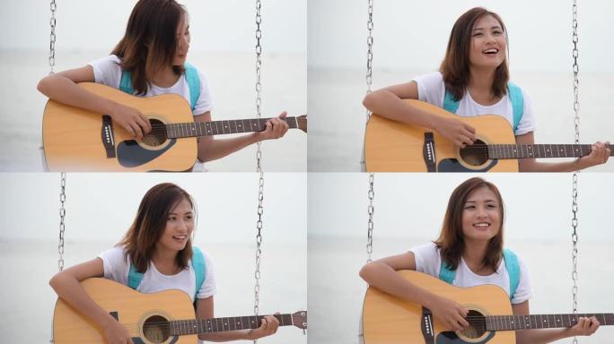 美丽的亚洲可爱女孩在海滩上玩木吉他。女人穿着休闲白色t恤，坐在热带海滩夏岛上，带着幸福的笑脸。自由旅