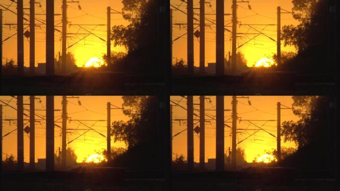 剪影中的日落铁路平交道口。电气化铁路。太阳在地平线上。工作日结束。火车撞车或灾难的危险路段