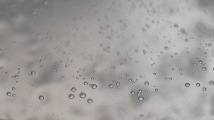 开水过程的宏观特写镜头。透明锅中带有气泡的蒸汽水的特写镜头