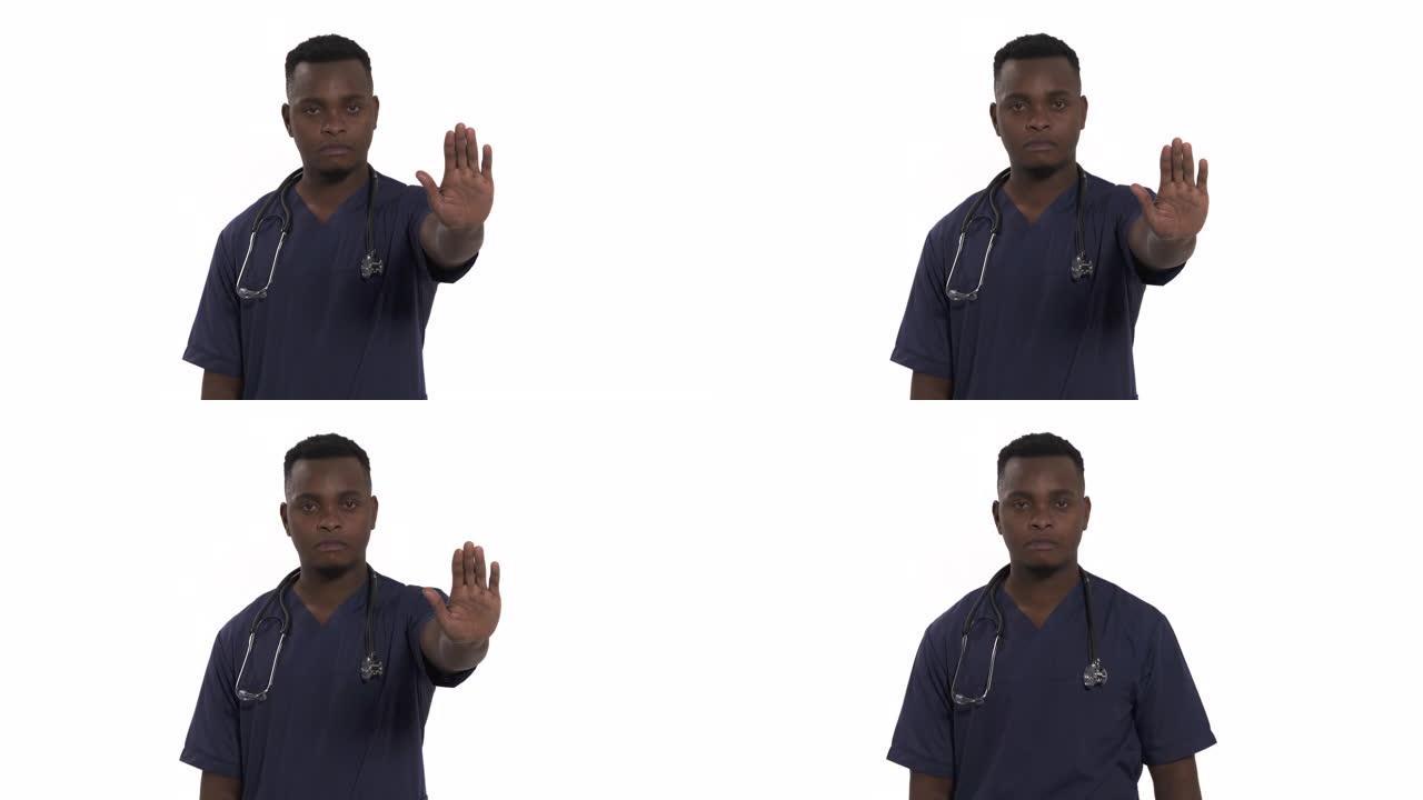 穿着专业医疗蓝色外套的严肃医生肖像，显示停止手掌标志拒绝手势。男子医生孤立在白色背景