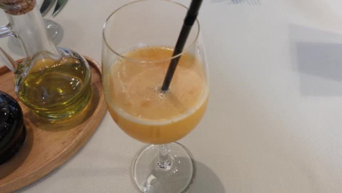 酒杯中的橙汁和油在餐厅的桌子上