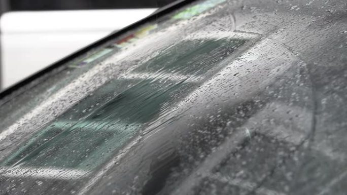 在雨天的白天，汽车的挡风玻璃上有水滴