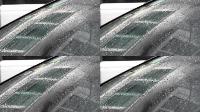 在雨天的白天，汽车的挡风玻璃上有水滴