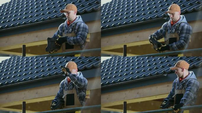 30多岁的工人手里拿着陶瓷屋顶瓦片准备工作。