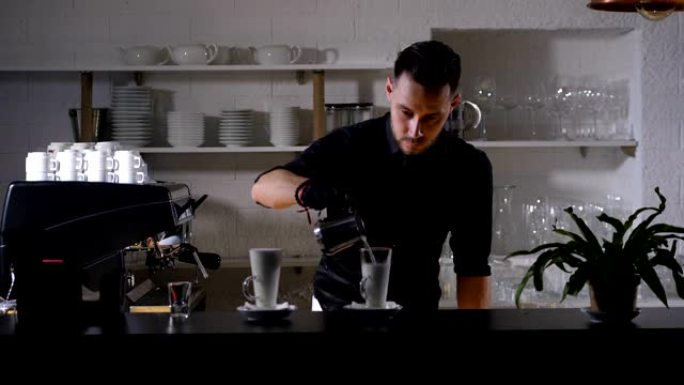 熟练的咖啡师用牛奶填充咖啡杯