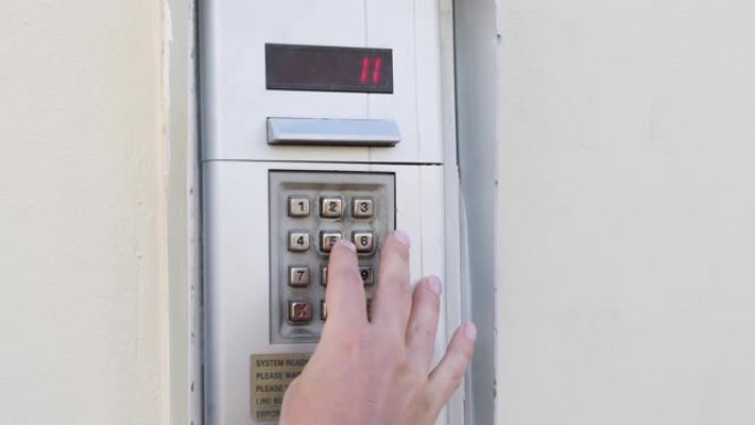 女性手指从门上输入数字代码的特写视图。女人从公寓拨打代码。女人输入数字代码