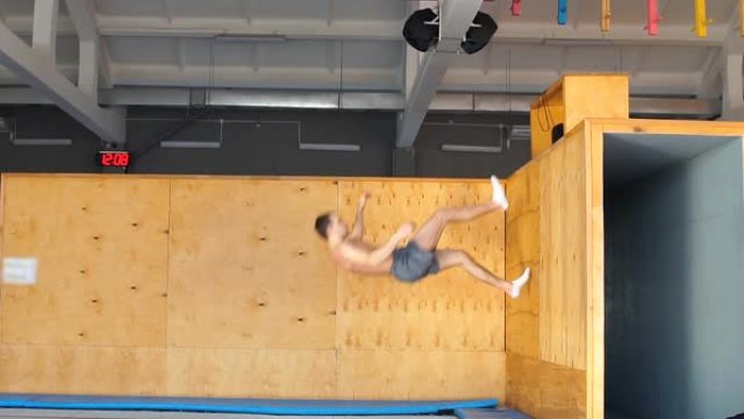 一个雄心勃勃的年轻运动员正在空中练习，他刚从木板上推下来