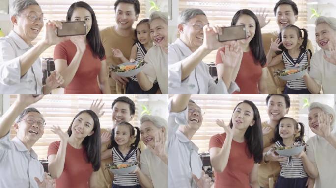 亚洲家庭高级母亲和父亲在幸福的厨房里用智能手机视频通话