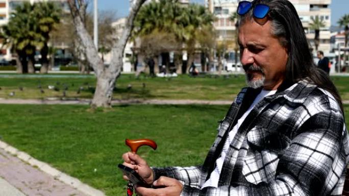 中年男子在城市公园使用智能手机