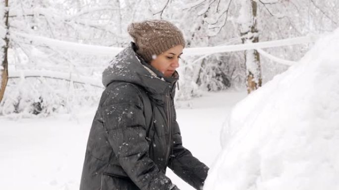 该名女子试图打开汽车结冰且积雪覆盖的后备箱。