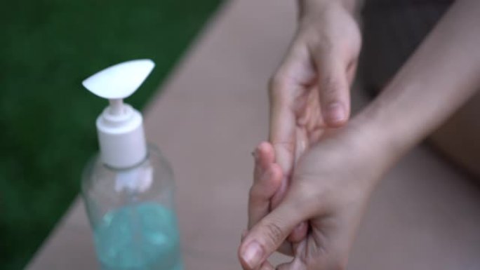 4k女性手部使用洗手液凝胶，搓手防菌，冠状病毒病新冠肺炎，洗手，杀菌，蓝色酒精凝胶瓶，卫生消毒，健康