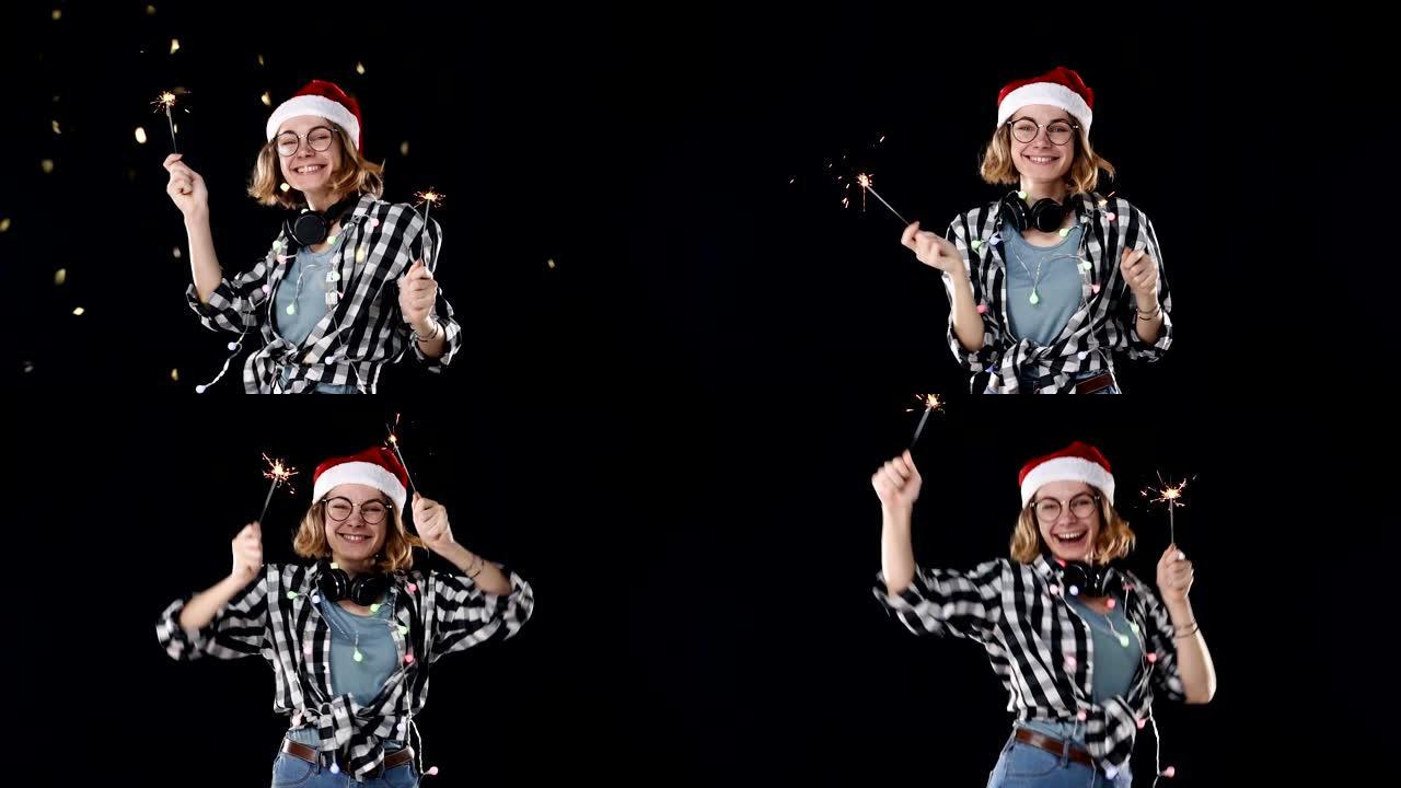 一个可爱的女人戴着圣诞老人的帽子，五颜六色的花环和脖子上的耳机，两个烟火在黑色背景的圣诞晚会上跳舞。