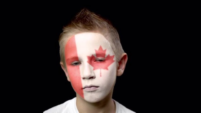 加拿大足球队的伤心球迷。脸上涂着民族色彩的孩子。