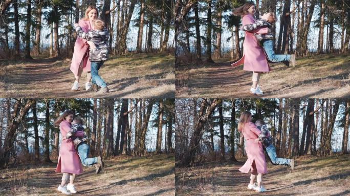 美丽的母子相向而行，在大自然中旋转。快乐的妈妈在公园里把她的男孩带到户外。爱的家庭观念。
