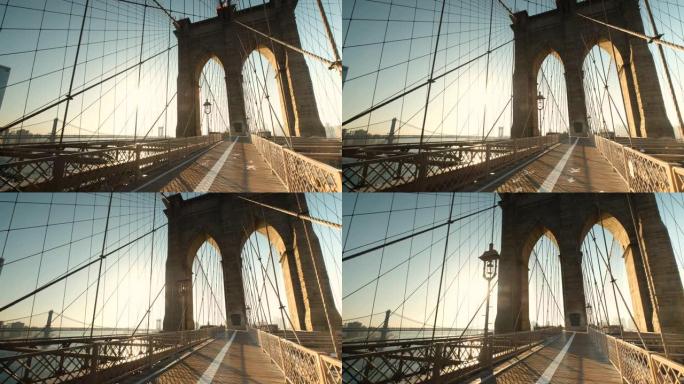 清晨，太阳升起在连接曼哈顿纽约和美国布鲁克林的东河上的布鲁克林大桥的路径上