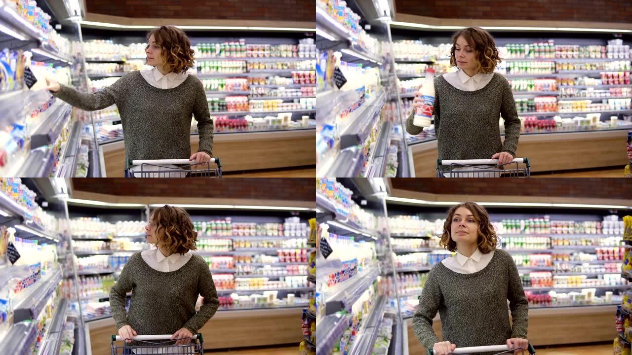 一位迷人的年轻女子在超市里散步，在靠近冰柜的货架上停下来，选择买一瓶新鲜牛奶，拿一瓶放在手推车上。慢