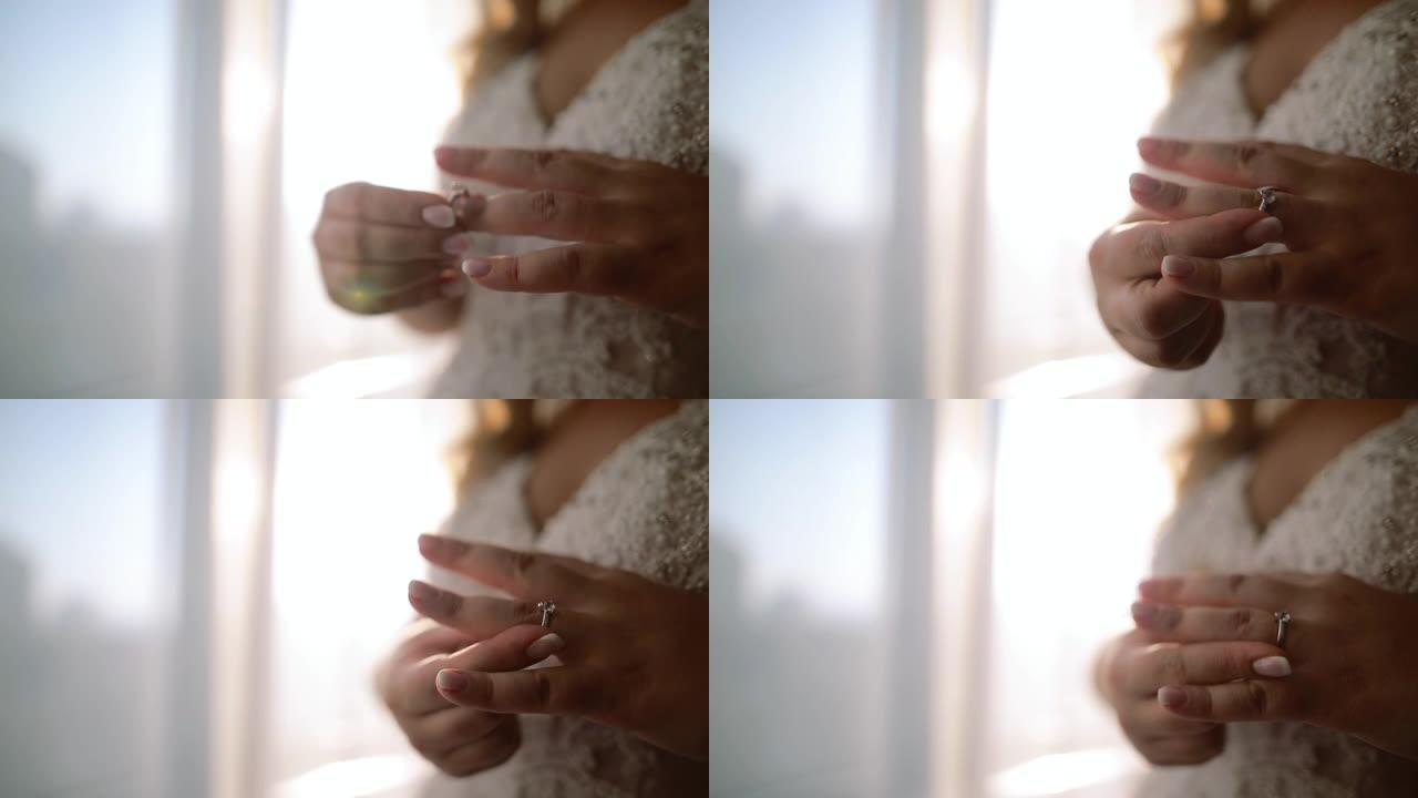 新娘站在窗户附近时将结婚戒指放在手上