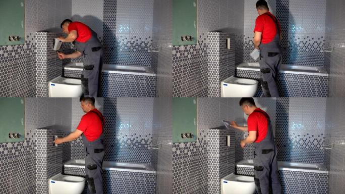 熟练工人在新的现代浴室中安装马桶冲水按钮