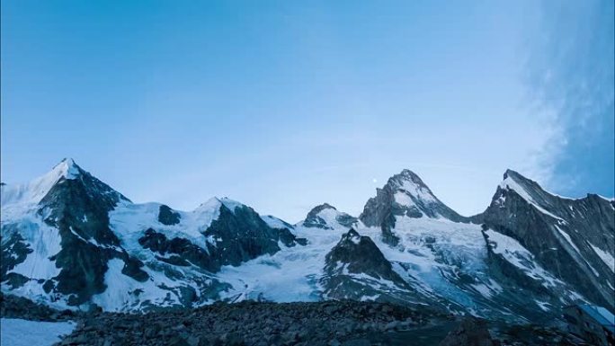 在月亮和灿烂的阳光下，雪山，木屋和步行的人的全景。延时