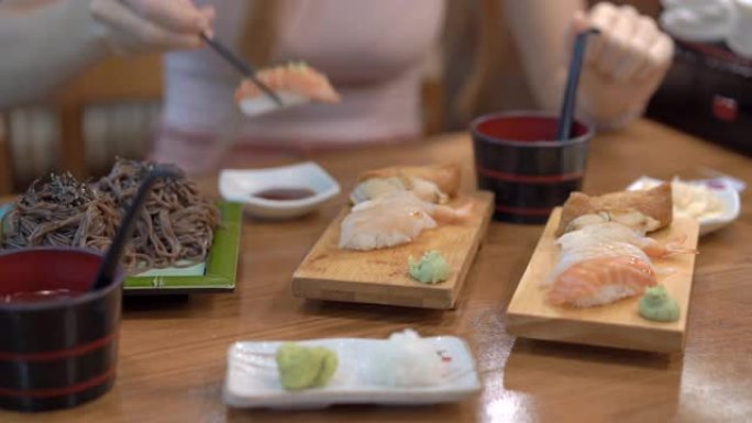 日本餐馆的一名年轻女子吃寿司。日本旅游概念