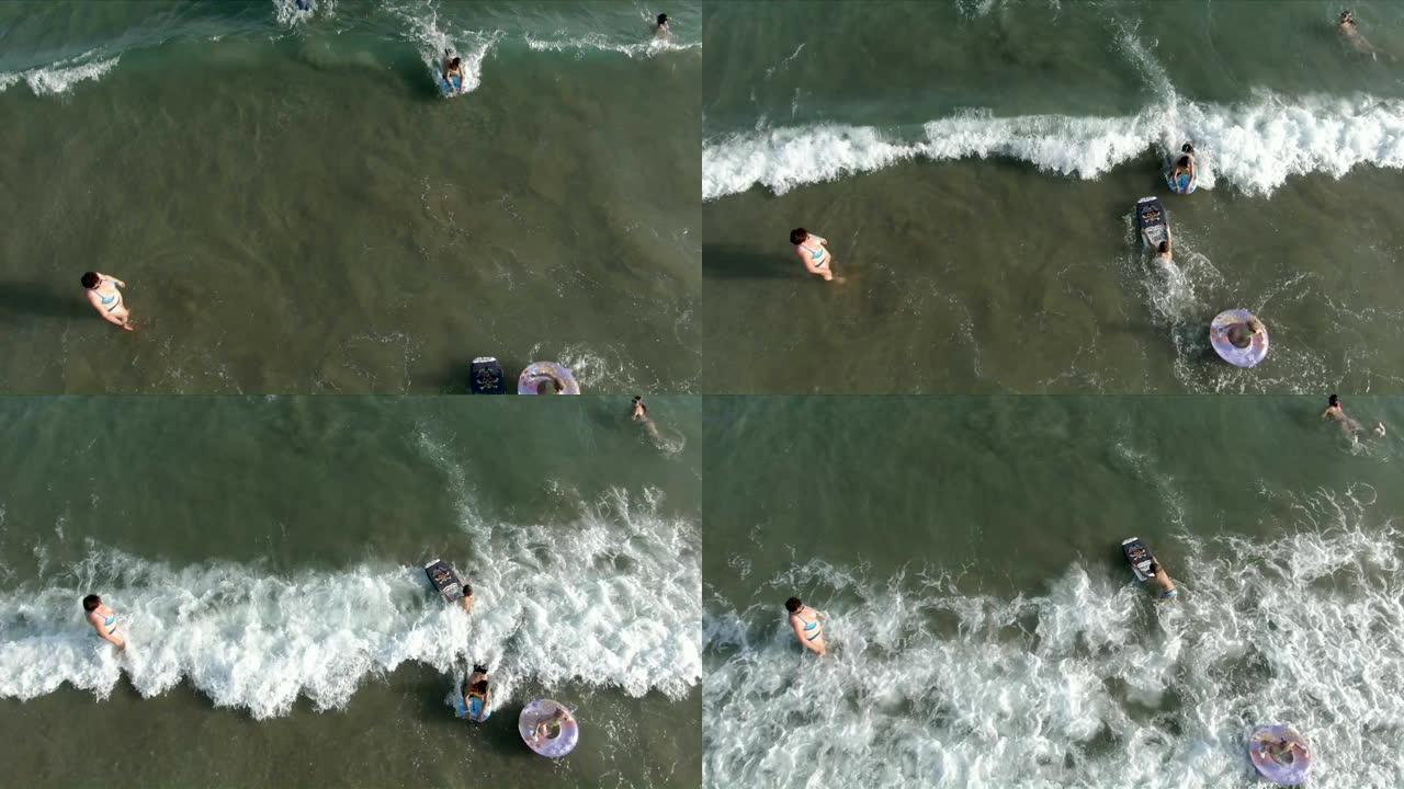 空中射击儿童在海浪上的充气甜甜圈上游泳