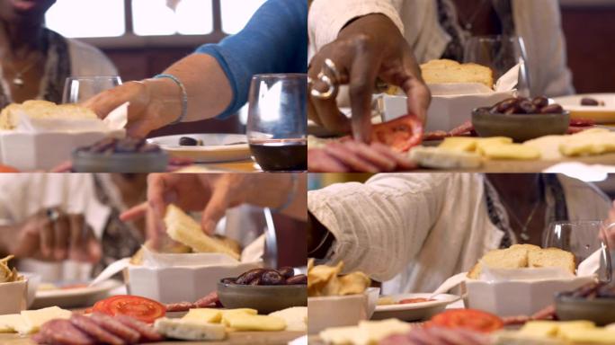 非裔美国妇女抓着切成薄片的番茄和其他小吃