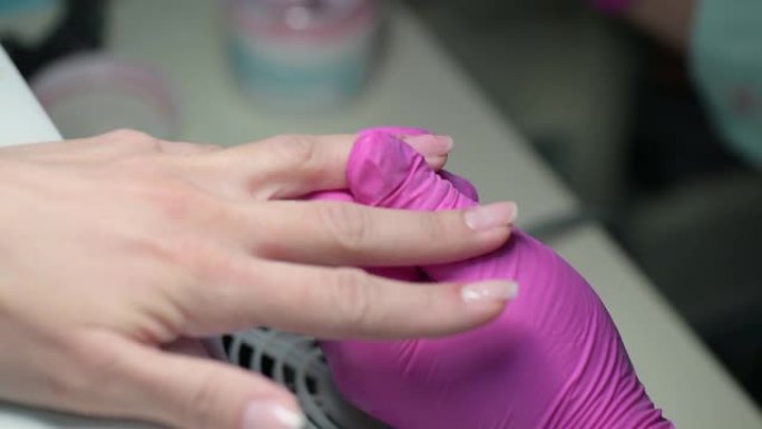 美甲美容师用凝胶抛光剂覆盖客户指甲的特写