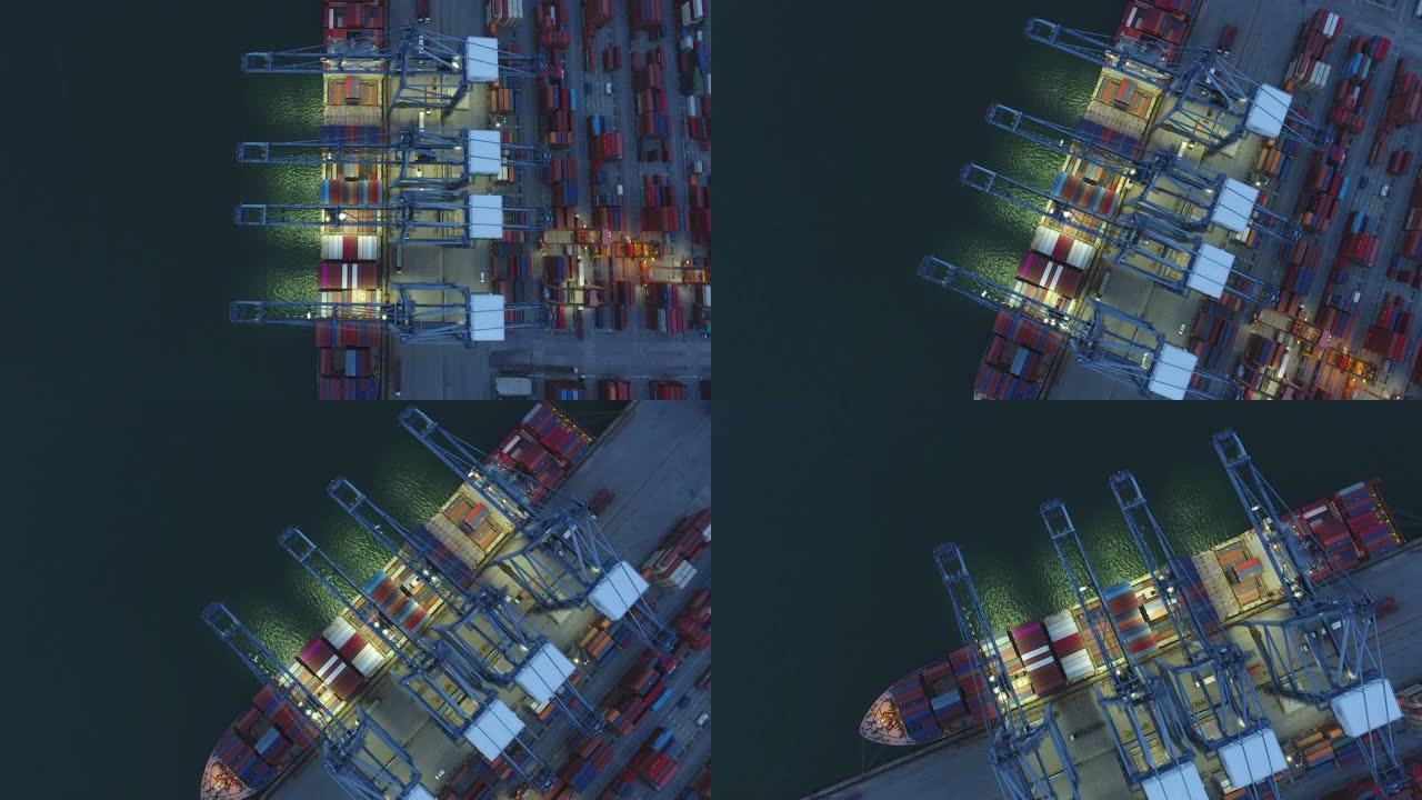 夜间工业港口的工作起重机和集装箱船，空中俯视图