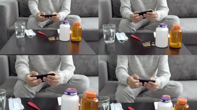 一个年轻人在家生病时在智能手机上玩电脑游戏的特写