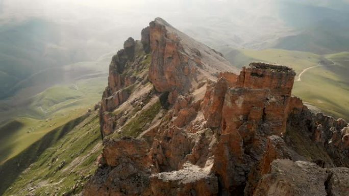 日落时无人机飞越尖锐的岩石露头的鸟瞰图。用于极端登山的陡峭的岩层山。飞行穿越旅行视频