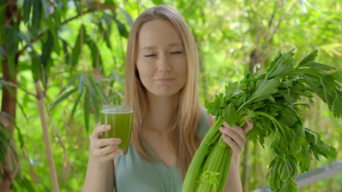 绿色环境中的一名年轻女子喝新鲜的芹菜汁