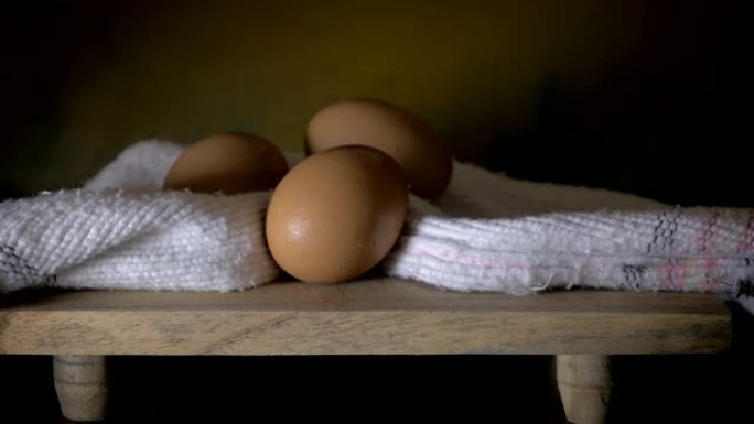 多莉在切菜板上拍摄了3个鸡蛋，类似于油画静物画