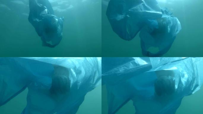塑料污染 -- 一个废弃的蓝色塑料袋，里面慢慢飘荡着水母。被困在塑料袋里的水母。水下射击，桶水母 (