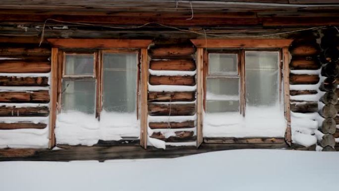 被雪覆盖的木屋。冬季景观中的俄罗斯村庄。西伯利亚。4K